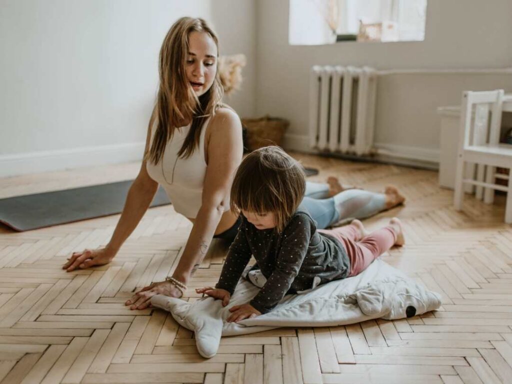 woman doing yoga pose with her son